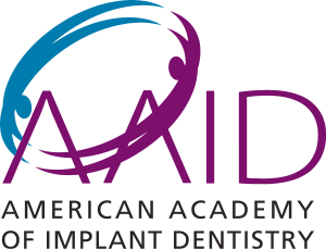 The image displays a logo with text, featuring a stylized graphic resembling a bird in flight with its wings outstretched, set against a background with a gradient of colors from blue at the top to purple and then to green at the bottom. The text on the logo reads  AID  in large white letters at the top, followed by  AMERICAN ACADEMY OF IMPLANT DENTISTRY  in smaller white letters below it. The style of the image is graphic with a modern design, commonly used for branding or as part of an organization s visual identity.