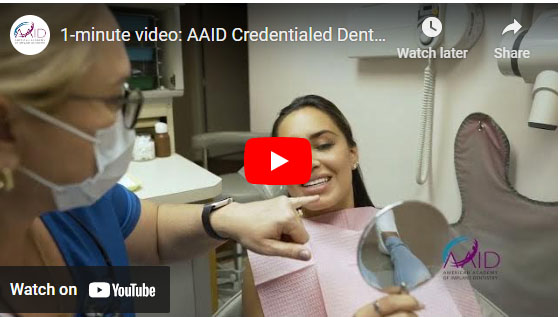 The image shows a screenshot of a YouTube video with a play button overlaying a thumbnail featuring two people, one wearing a surgical mask and the other receiving dental care, set against a backdrop that suggests a dental office environment.